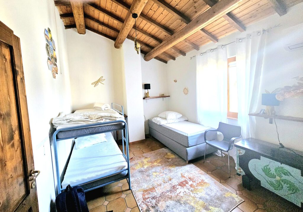 Kinderslaapkamer met stapelbed en eenpersoonsbed in Villa Marolo in Zuid-Sardinië